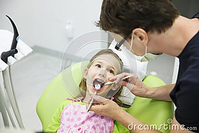 Girl sitting on dental chair on her regular dental checkup Stock Photo