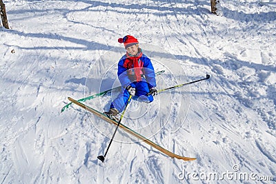 Girl sitting down on the snow learning skiing Stock Photo
