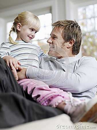 Girl Sitting On Father's Lap In House Royalty Free Stock Photography