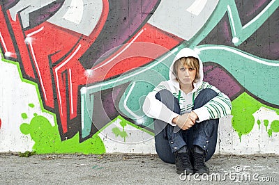 Girl sitting on the floor near graffiti wall Editorial Stock Photo