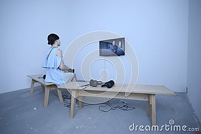 Girl sitting in an interactive room and watching a film on monitor Editorial Stock Photo