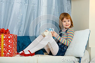 Girl is sitting next to a gift Stock Photo