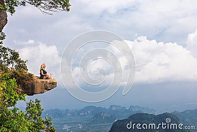 Girl sitting at the stone rock. Picturesque observation point Editorial Stock Photo