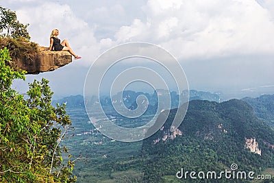 Girl sitting at the stone rock. Picturesque observation point Editorial Stock Photo