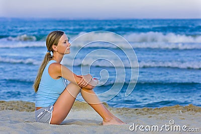 Girl sitting on white sand on the beach Stock Photo