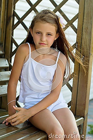 Girl sitting on a wooden bench Stock Photo