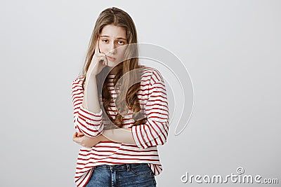 Girl almost sleeps from boredom during class. Portrait of indifferent tired female model supporting head with hand Stock Photo