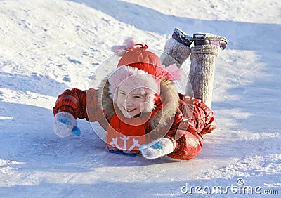 Girl sliding down a frozen hill Stock Photo