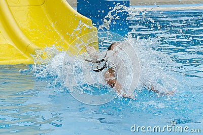 Girl sliding down water slide Stock Photo