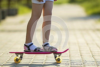 Girl slim legs in white socks and black sandals standing on pave Stock Photo
