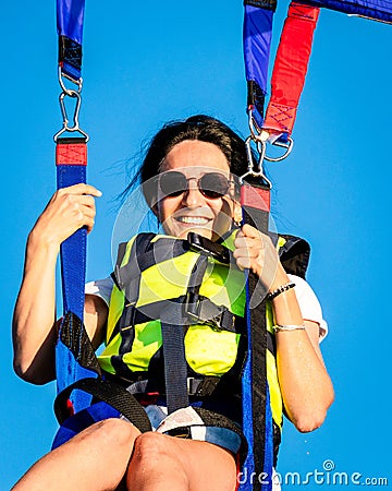 Girl smile in parasail parashute mid-air. Parasailing safety and experience concept Stock Photo