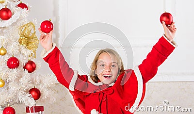 Girl smiling face hold balls ornaments white interior background. Let kid decorate christmas tree. Favorite part Stock Photo