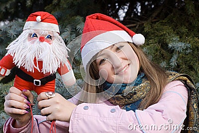 Girl smiling holding Santa doll Stock Photo