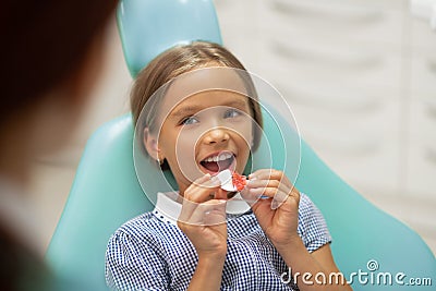 Girl smiling while putting mouth guard on her own Stock Photo