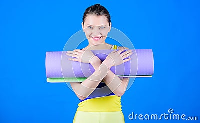 Girl smiling slim fit athlete hold fitness mat. Fitness and stretching. Stretching muscles. Getting into the yoga groove Stock Photo