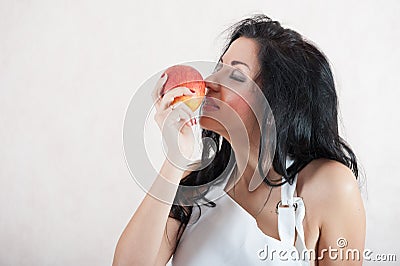 Girl sniffs an apple. Portrait of a girl with an apple. Apple pleasure Stock Photo