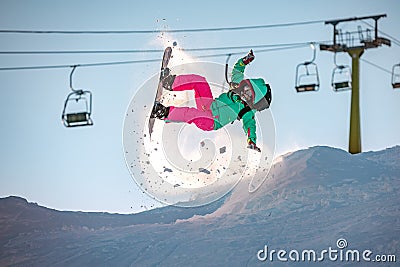 Girl snowboarder jumps and fails on snowboard Stock Photo