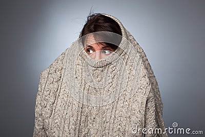 A girl with a social phobia hides her face in a sweater. Stock Photo