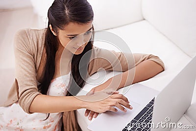 Girl on sofa with laptop, search and relax with remote work, website and browse in living room. Woman on couch with Stock Photo