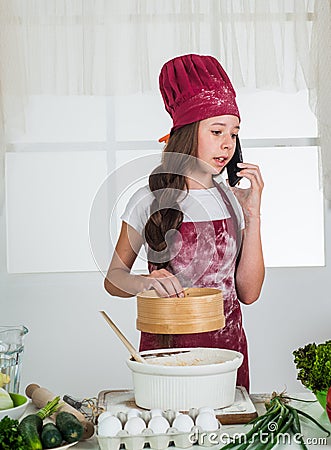 Girl soiled in flour in kitchen, cooking Stock Photo