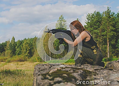 Girl soldiers take aim from the gun being on a hill Stock Photo