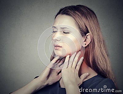Girl with sore throat neck colored in red. Sick woman having pain in throat Stock Photo