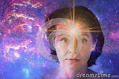 girl with soulful look against background of starry sky. on forehead of girl glowing star symbol of open mind. paranormal Stock Photo