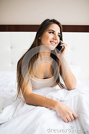 Girl speak phone in the bed Stock Photo