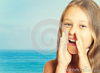 Girl speaks through cupped hands Stock Photo