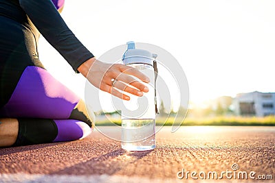 girl sportsman crossfit and squats agains at sunset in the stadium drink water Stock Photo