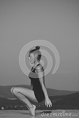 Girl sportswoman. Woman gymnast in black sportswear in yoga pose. Stock Photo