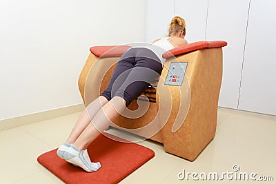 Girl in sportwear using relax massage equipment healthy spa salon Stock Photo