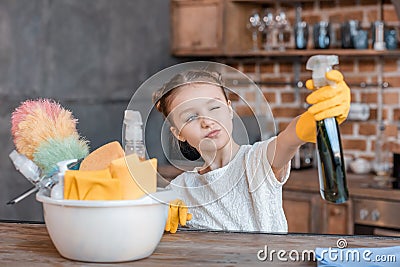 Girl with spray bottle and different cleaning supplies at home Stock Photo