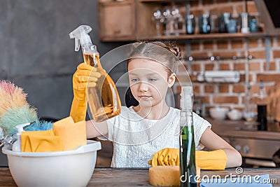 Girl with spray bottles and different cleaning supplies at home Stock Photo