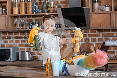 Girl with spray bottles and different cleaning supplies at home Stock Photo