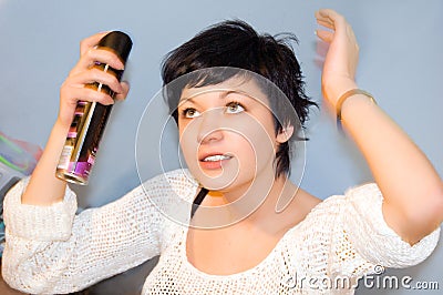 Girl spraying hair lacquer onto her hair Stock Photo