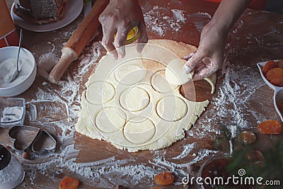 The girl squeezes round shapes out of the dough with a glass Stock Photo