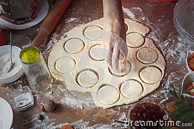 The girl squeezes round shapes out of the dough with a glass Stock Photo