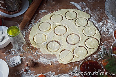 The girl squeezes round shapes out of the dough with a glass Stock Photo