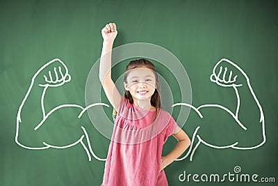 Girl standing against chalkboard and strong winner concept Stock Photo