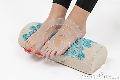 girl standing on applicators doing foot massage on a massage Mat Stock Photo