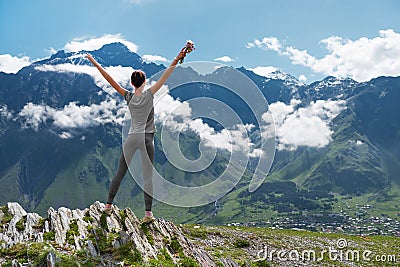 Girl standing edge of cliff and looking at mountain landscape Stock Photo