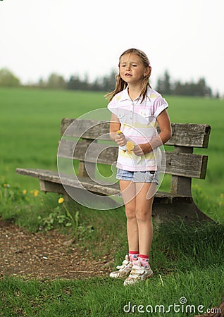 Girl standing in front of bench Stock Photo