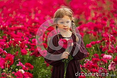 girl in a cherry dress and pigtails collects bright pink flowers Stock Photo