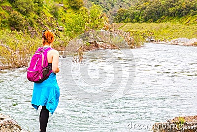 Girl Standing on Rocks Near Fast River Stock Photo