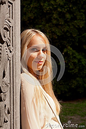 Girl standing sun stone pillar, Groot Begijnhof, Leuven, Belgium Stock Photo