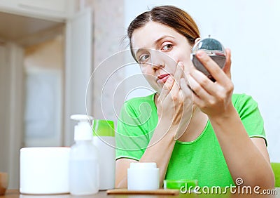 Girl stares on face in mirror Stock Photo