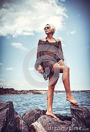 Girl on stone coast near sea Stock Photo