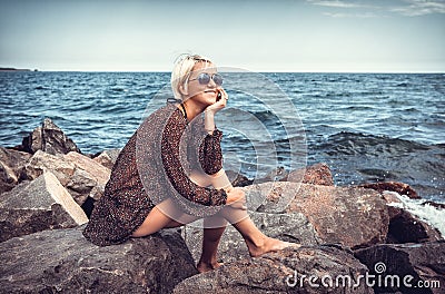 Girl on stone coast near sea Stock Photo