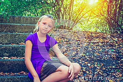Girl on stone steps in the park Stock Photo